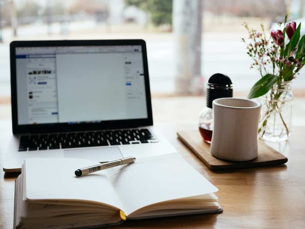 notebook-pen-laptop-coffee-mug-oak-table-content-writing